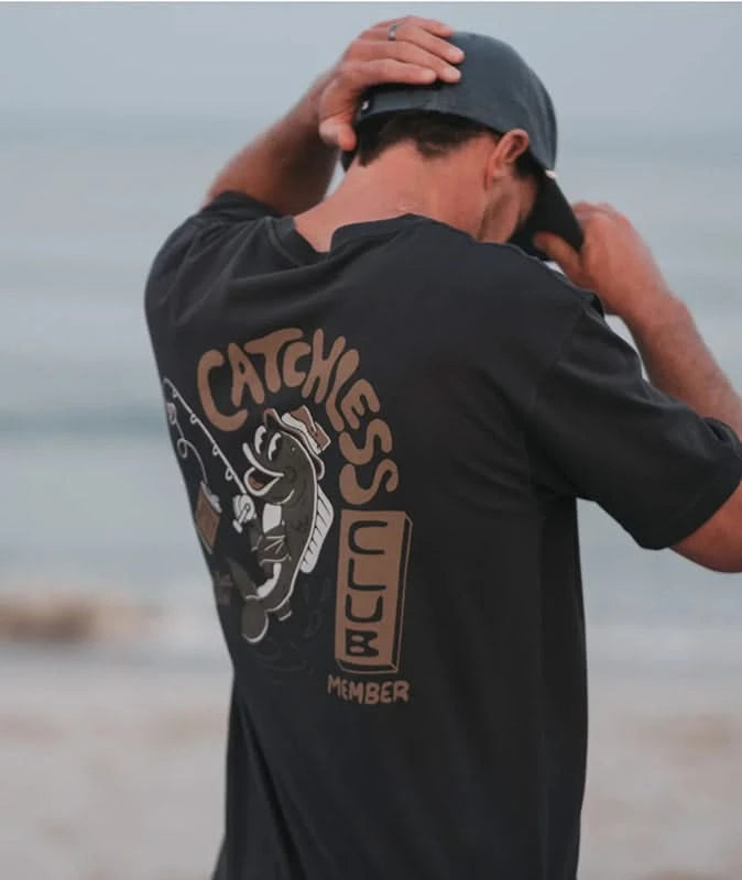Model Wearing Jetty Catchless Club T-shirt in Black with large graphic on the back, Flat lay  Rear view