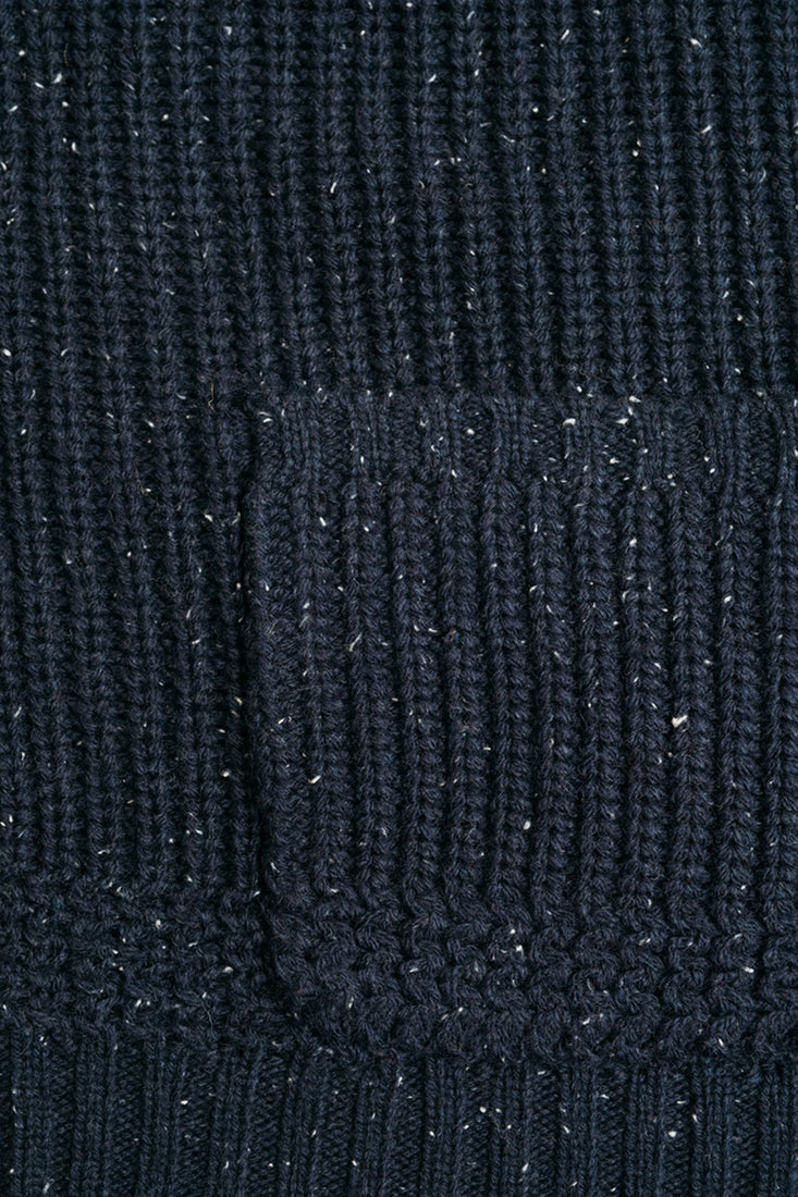 Detailed shot of navy Donegal cardigan patch pocket and speckled ribbed knit texture