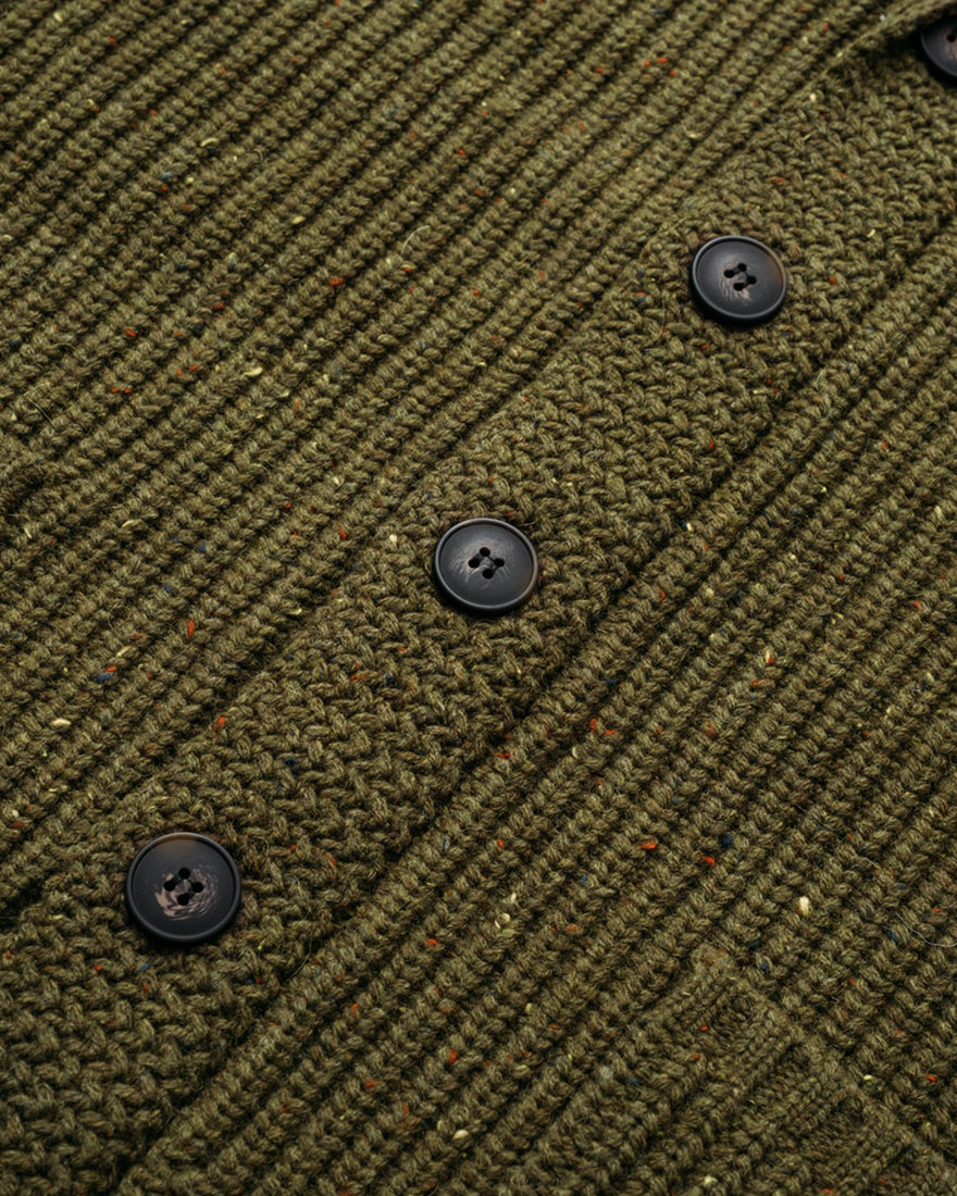 Close-up of Donegal-inspired olive cardigan showing ribbed knit texture, tonal buttons, and speckled wool blend