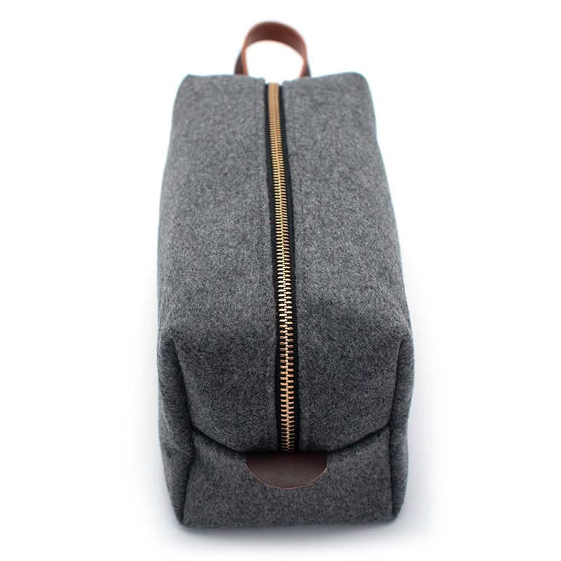Front view of Grey Heather Cashmere toiletry bag with durable wool exterior and centered brass zipper