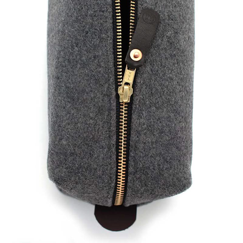 Close-up of brass YKK zipper and black leather pull tab on Grey Heather Cashmere dopp kit