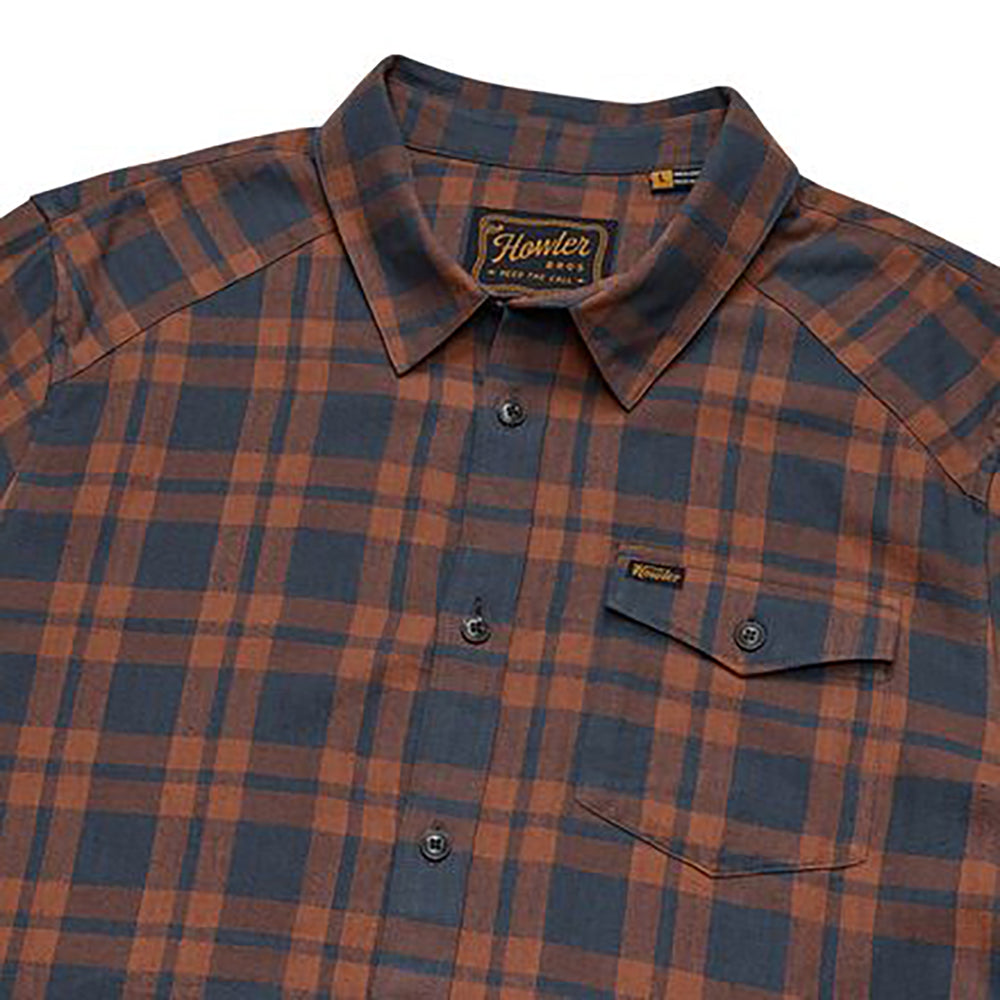 Close-up of Howler Brothers La Grange Lightweight Flannel Shirt in rust and navy plaid showing front pocket and button details
