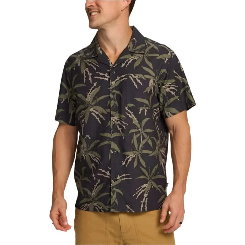 Model wearing Howler Brother's Momoloha Shirt, lily negatives pattern, black with green, front  view