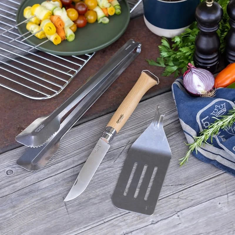 Opinel Grilling set, includes Knife, spatula attachment, and tongs, in picnic setting
