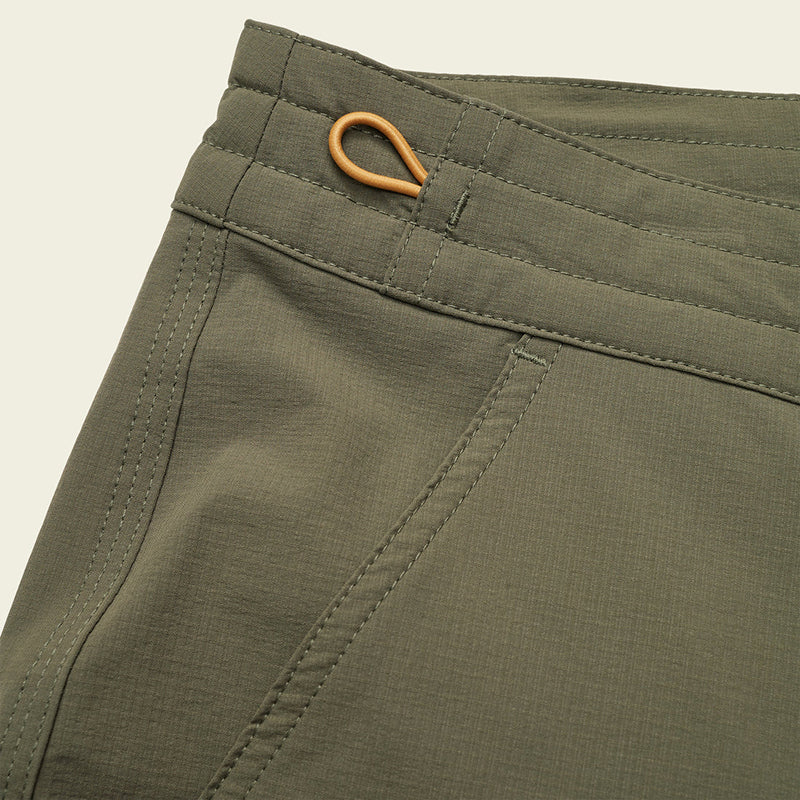 Model Wearing Howler Brothers Shoalwater tech pants in oregano color, close up fabric detail view