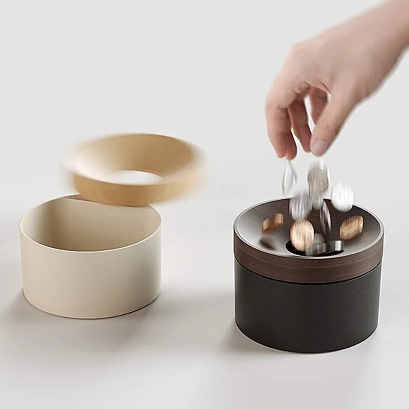 Hand dropping coins into black Revov Magnetic Coin Storage with lid removed. Clean, modern coin organizer with interactive sliding magnetic lid.