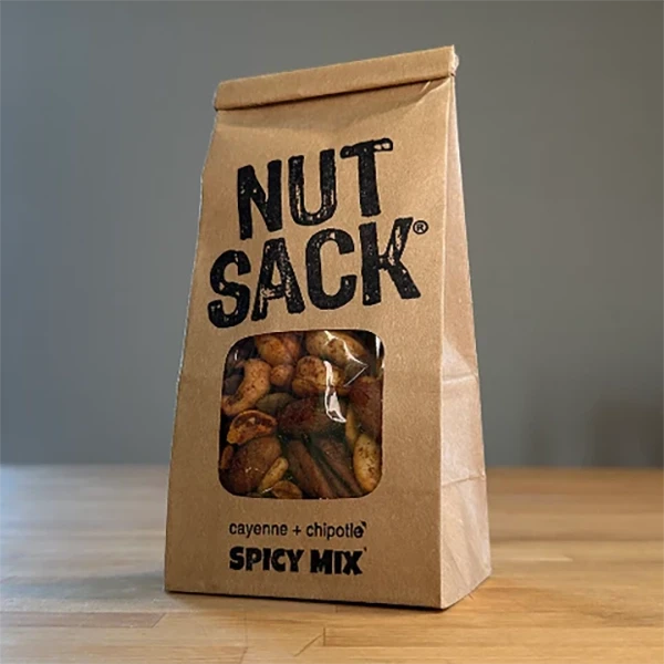 Nut Sack Spicy Mix, 6oz snack bag, front of bag, stylized on a table