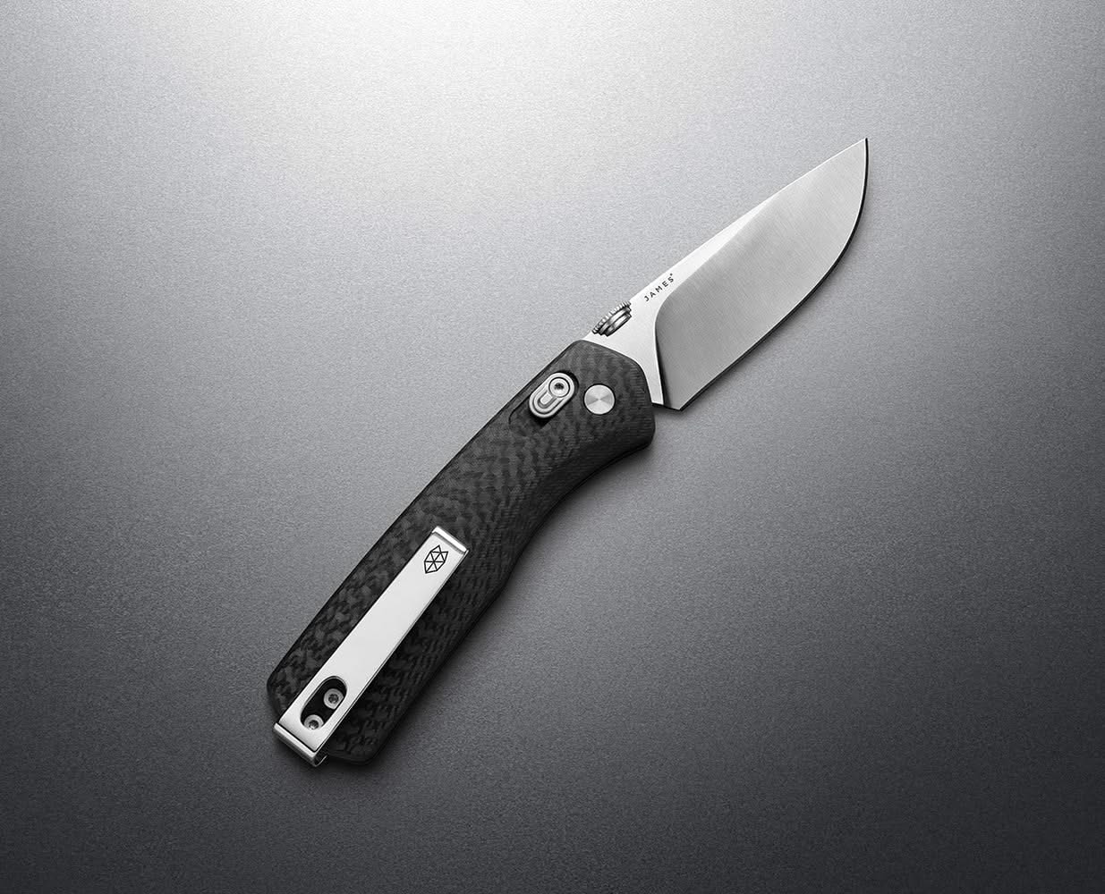 Top-down view of Carter Knife with carbon fiber Micarta scales and VG-10 blade, laid on matte steel background – part of the EDC collection at The Simple Man.
