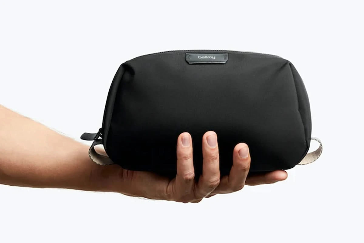 Bellroy Toiletry Kit in black, closed view in models hand for size comparison