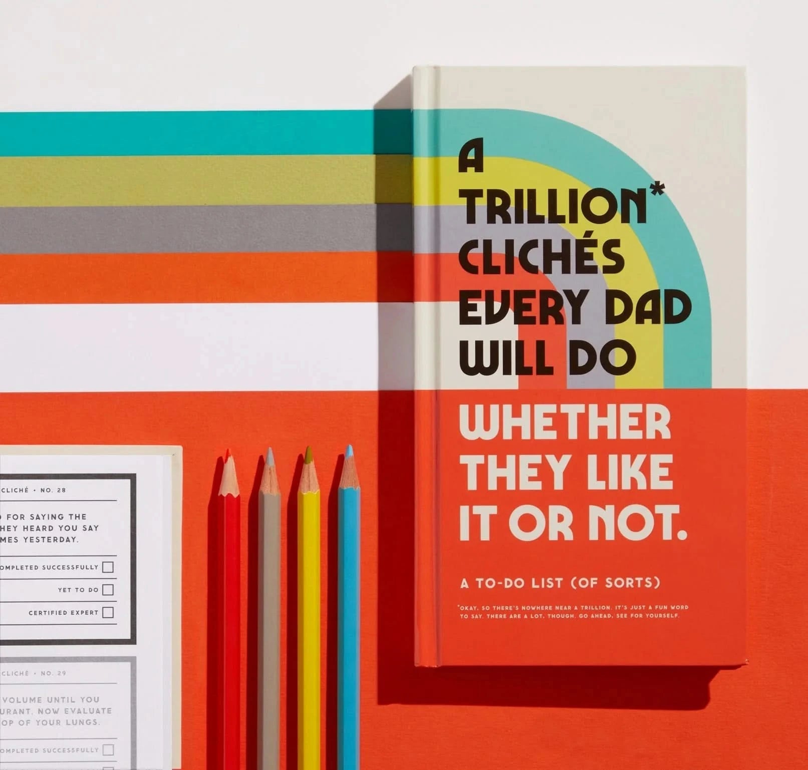 Stylized photo of the dad journal next to colored pencils and journal pages, showcasing its vibrant cover and playful tone.