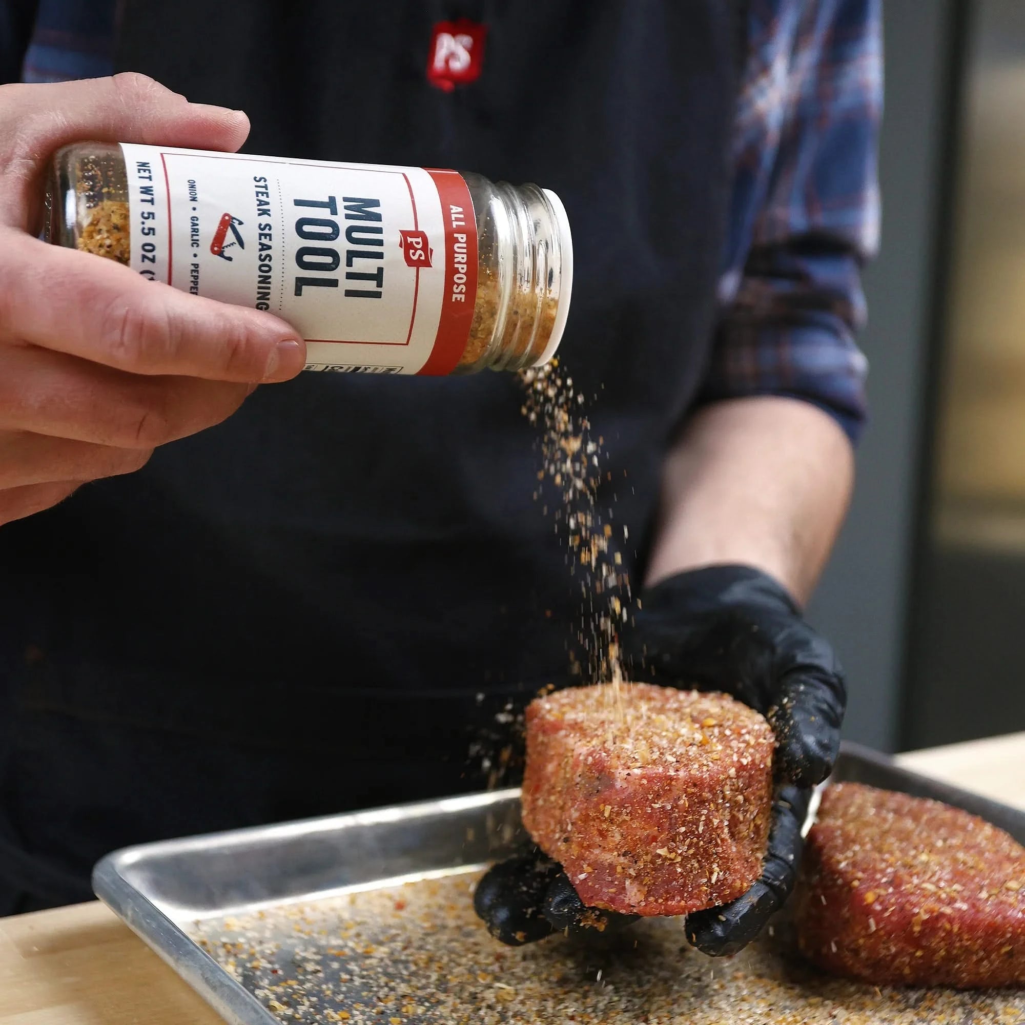 Man seasoning steak with Multi-Tool All Purpose Steak Seasoning from The Simple Man