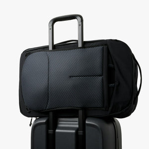 Bellroy Lite Travel Pack 38L carry-on backpack in Black, riding on a suitcase handle with luggage pass-through - The Simple Man