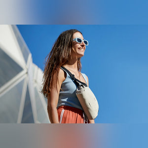 Bellroy Lite Sling Mini, worn across the chest by a woman in sunglasses outdoors - The Simple Man