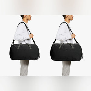 Bellroy Venture Duffel 40L in Black, carried over the shoulder, front and side views - The Simple Man