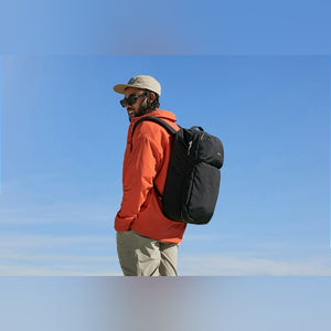 Bellroy Lite Travel Pack 38L in Black, worn by a man in an orange jacket outdoors - The Simple Man