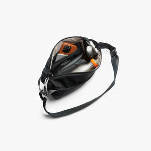 Bellroy Lite Sling in Black, worn across the body with the strap visible - The Simple Man
