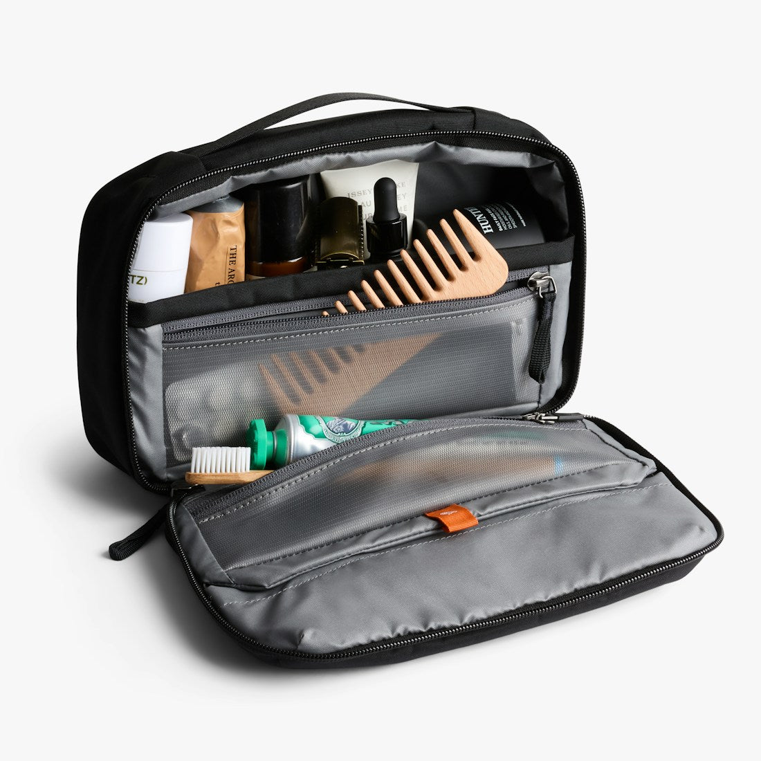 Bellroy Hanging Toiletry Kit in Black, open with toiletries and a comb inside - The Simple Man