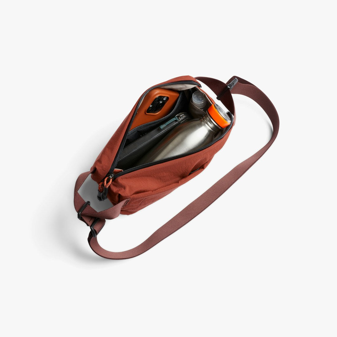 Bellroy Lite Sling Mini in Clay, worn across the body with the strap visible - The Simple Man
