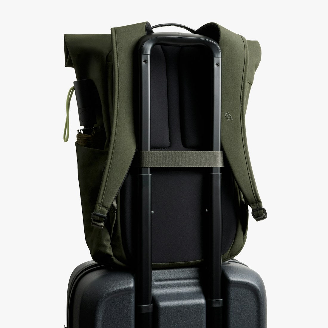 Bellroy Classic Rolltop commuter backpack in Olive, back view riding on a suitcase handle with luggage pass-through - The Simple Man
