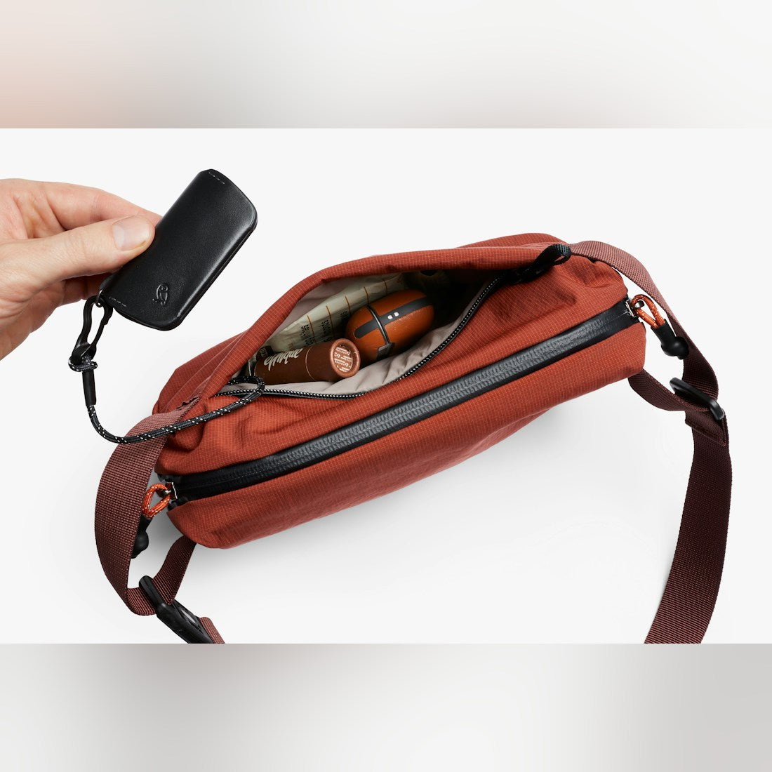 Bellroy Lite Sling Mini in Clay, open top view with contents - The Simple Man