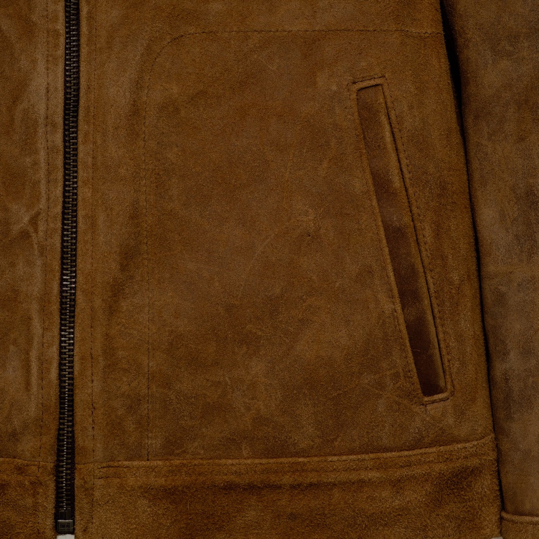 Close-up of the lower front pocket and zipper on the brown rough-out suede jacket - The Simple Man