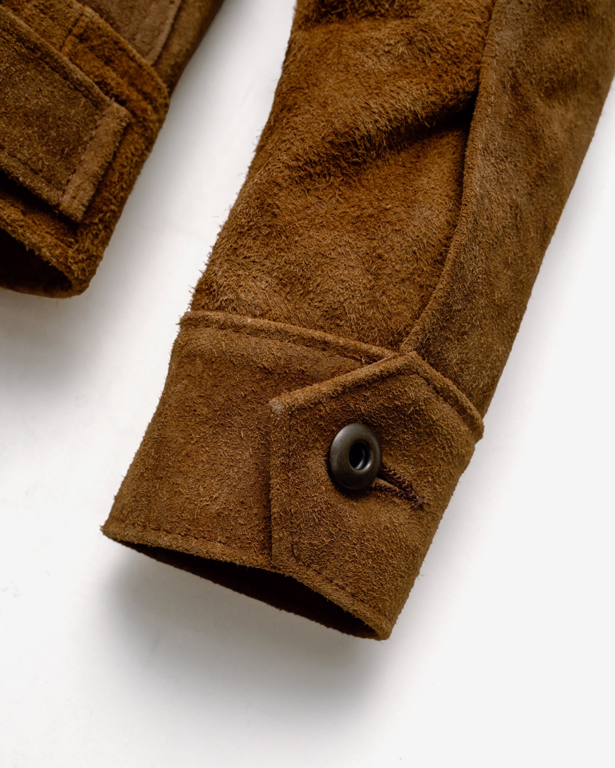 Close-up of the button cuff closure on the brown rough-out suede jacket sleeve - The Simple Man