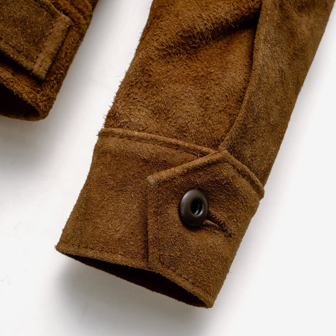 Close-up of the button cuff closure on the brown rough-out suede jacket sleeve - The Simple Man