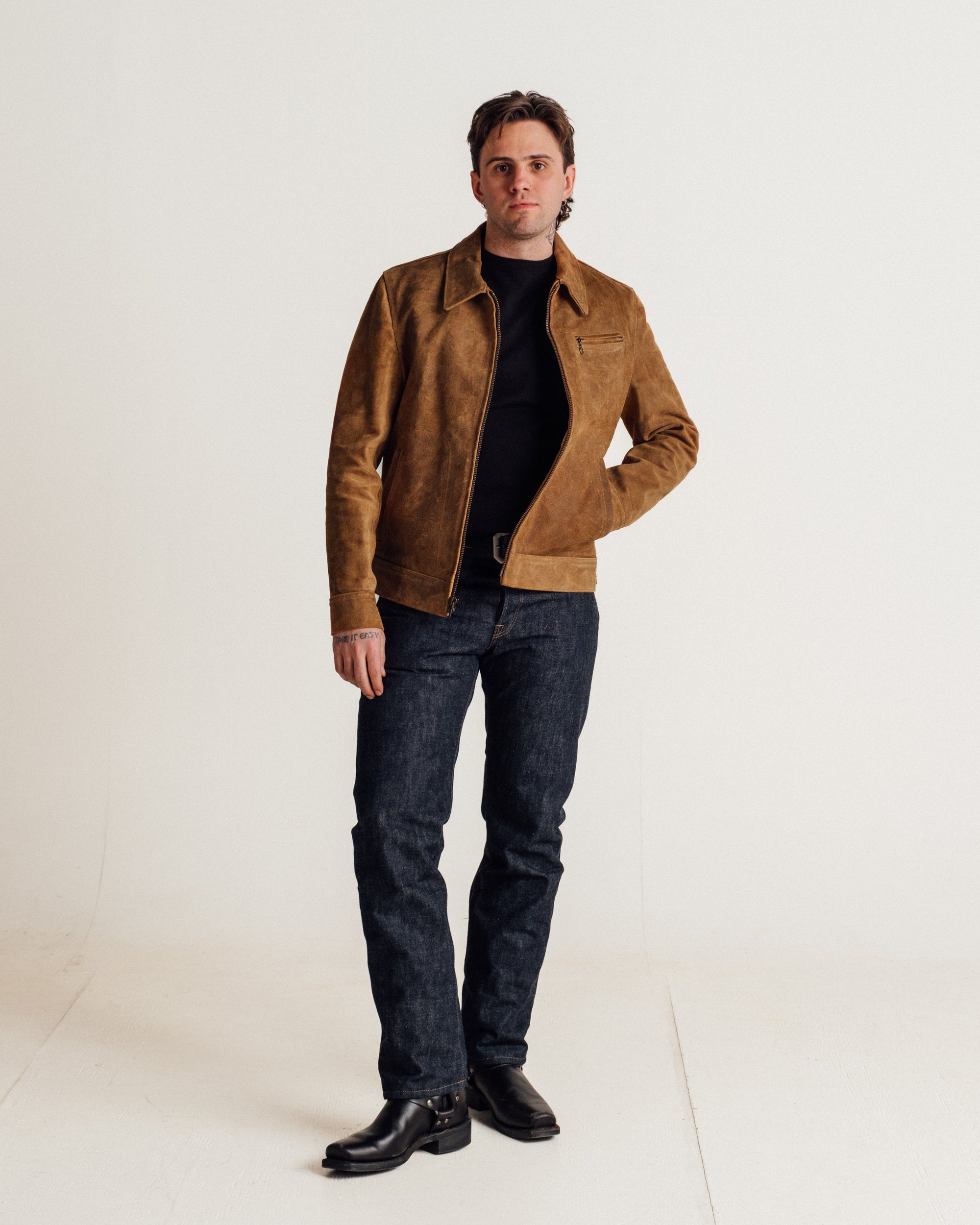 Full length view of a man wearing the brown rough-out suede jacket with dark jeans and boots - The Simple Man