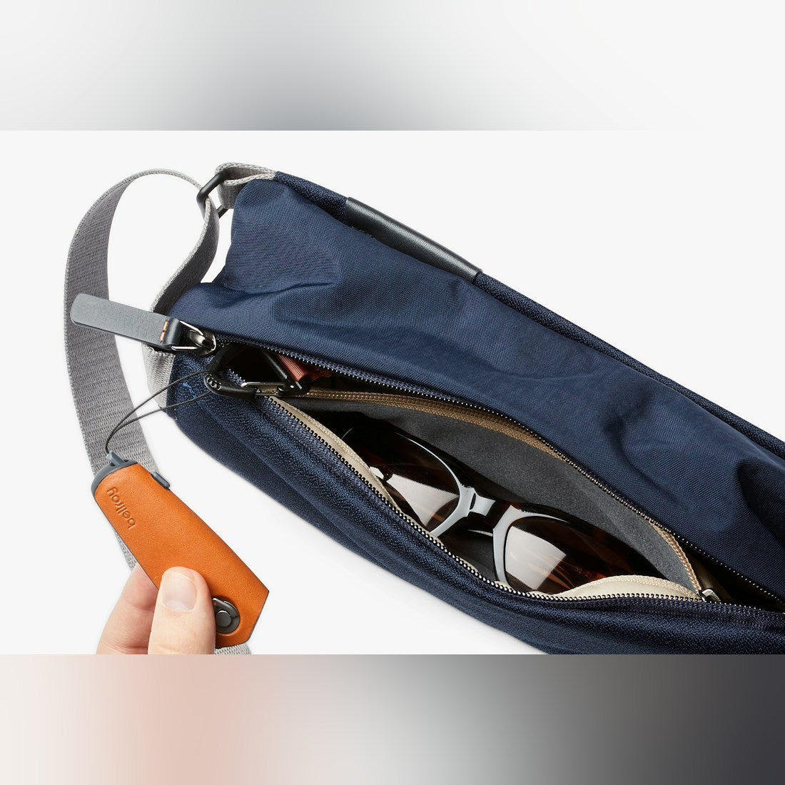Bellroy Sling Mini sling bag in Navy, open top view with contents - The Simple Man