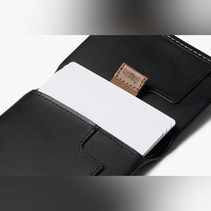 Bellroy Slim Sleeve wallet in Black, close-up of a card in the front pocket with pull tab - The Simple Man