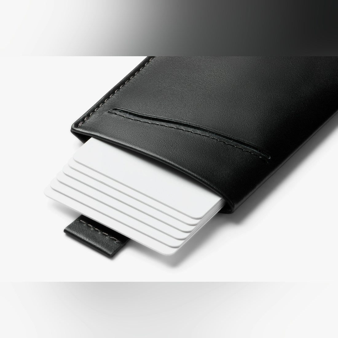 Bellroy Card Sleeve wallet in Black, stack of cards sliding out of the front slot - The Simple Man