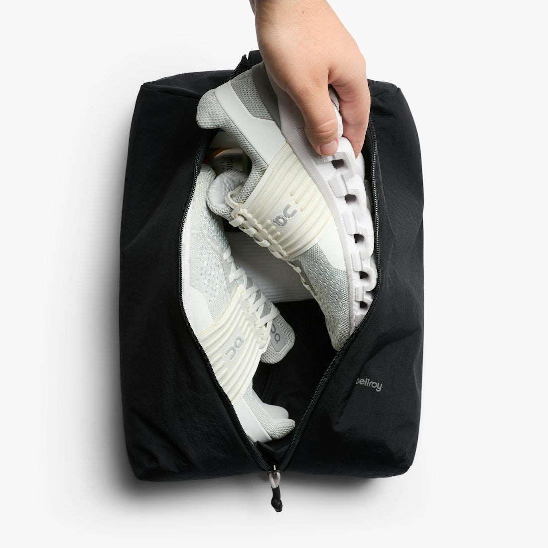 Bellroy Lite Packing Caddy 10L in Black, hand placing a shoe into the caddy - The Simple Man