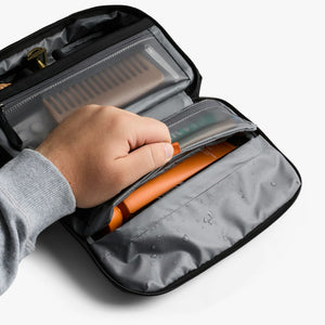 Bellroy Hanging Toiletry Kit in Black, hand reaching into the front pocket - The Simple Man