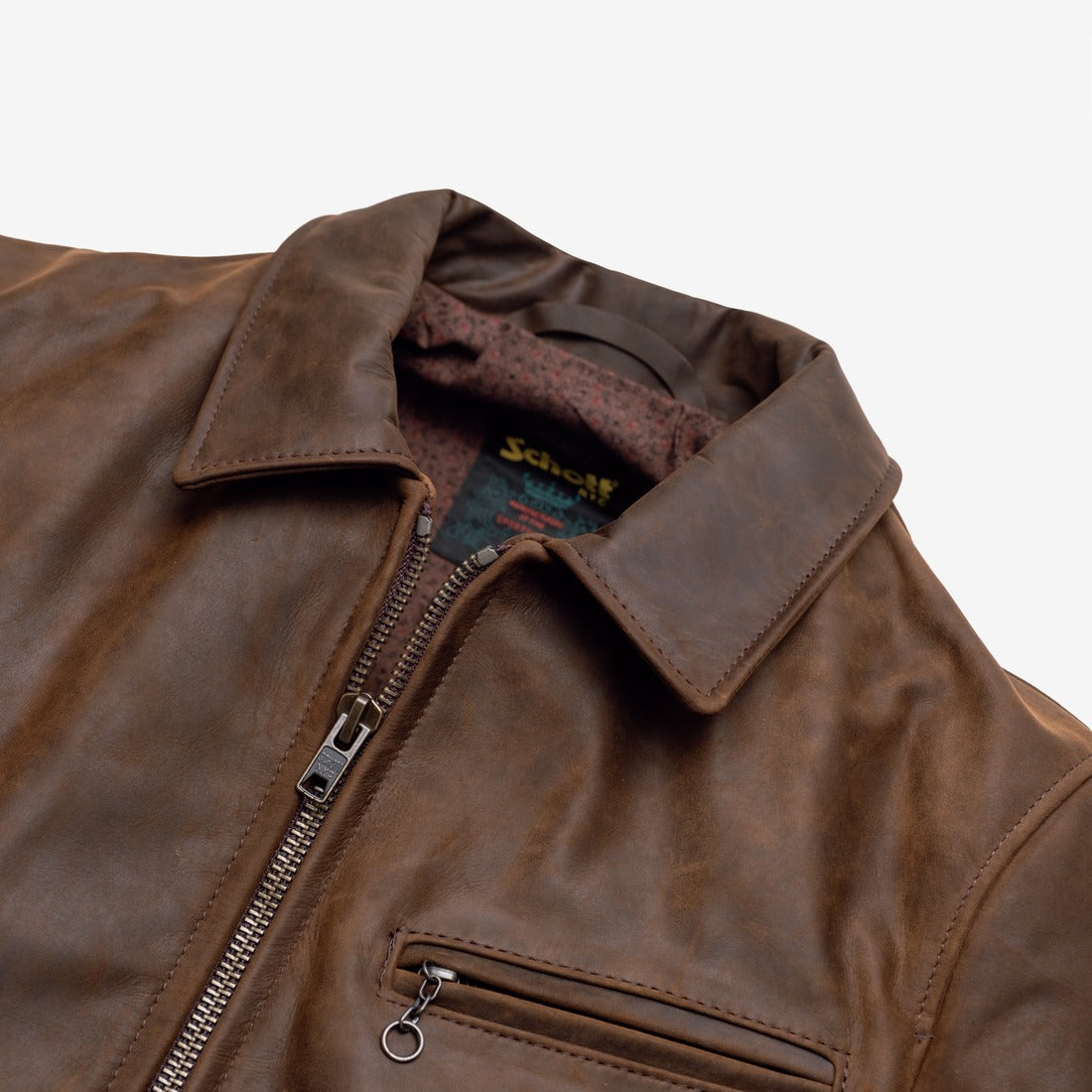 Close-up of the collar, zipper and diagonal zippered chest pocket on the brown cowhide trucker jacket - The Simple Man