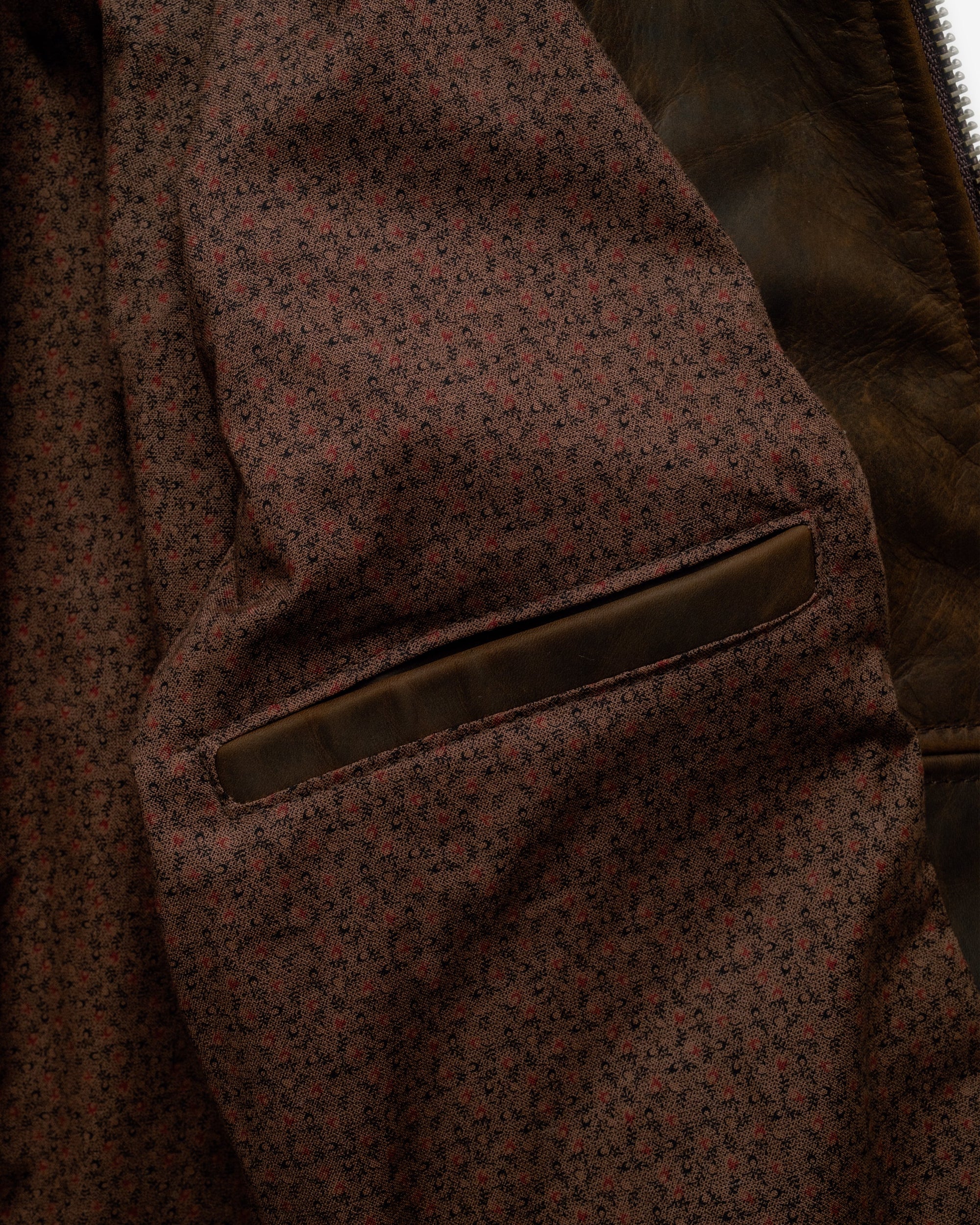 Inside of the brown cowhide trucker jacket showing the vintage mini print cotton lining and inside pocket - The Simple Man