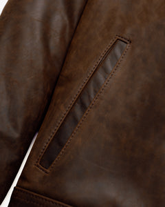 Close-up of the welt side entry pocket on the brown cowhide trucker jacket - The Simple Man