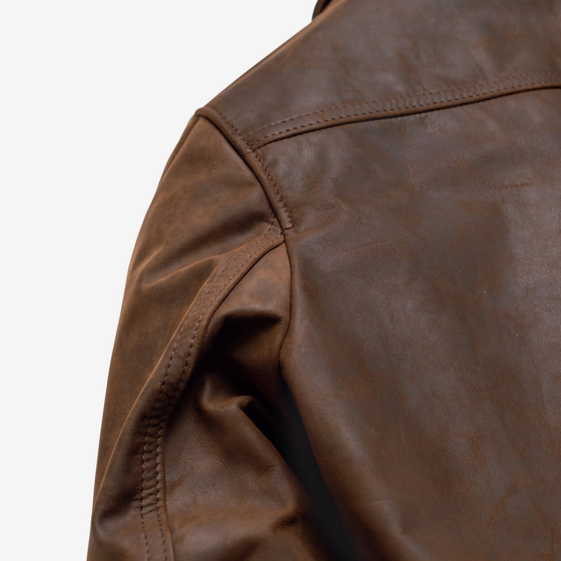 Close-up of the shoulder and sleeve of the brown cowhide trucker jacket showing the pull-up leather finish - The Simple Man