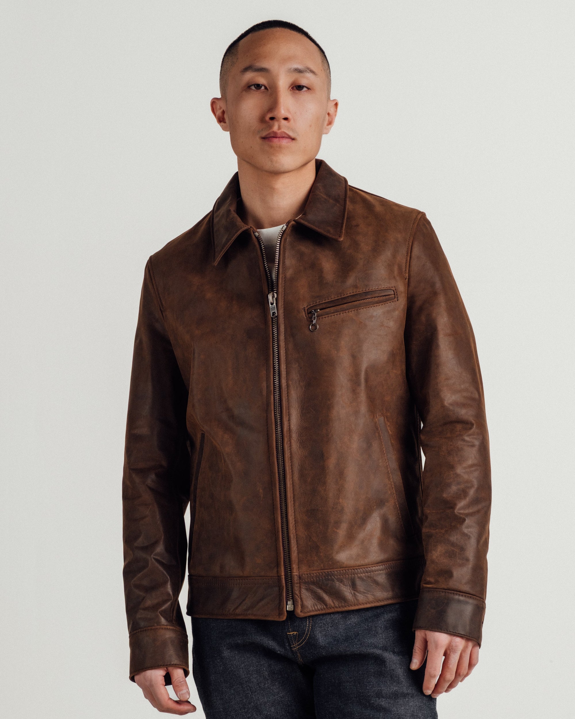 Man wearing the brown cowhide trucker jacket zipped, front view on model - The Simple Man