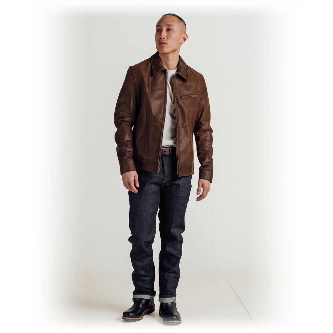 Full length view of a man wearing the brown cowhide trucker jacket with dark jeans and boots - The Simple Man