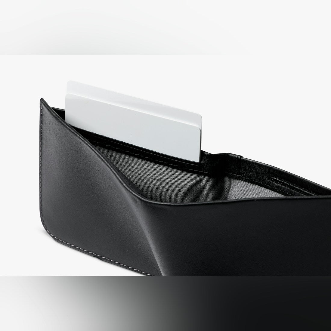 Bellroy Hide & Seek RFID leather wallet in Black, close-up of a card tucked in a slot - The Simple Man