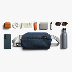 Bellroy Sling Mini in Navy, flat lay with everyday items - The Simple Man