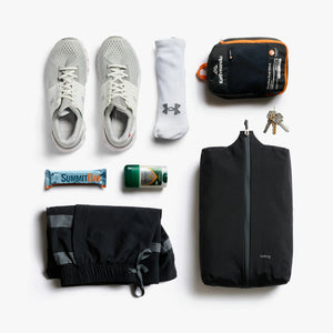 Bellroy Lite Packing Caddy 10L in Black, flat lay with sneakers and travel items - The Simple Man