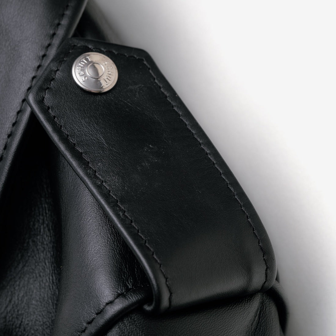 Close-up of the snap shoulder epaulet on the black Perfecto steerhide jacket - The Simple Man