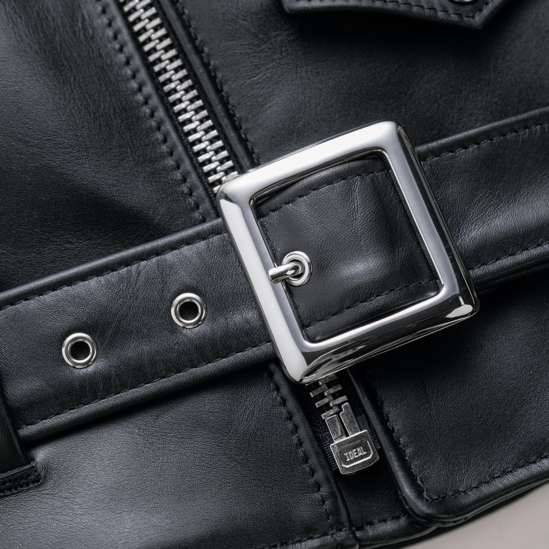 Close-up of the nickel plated square belt buckle and grommets on the black Perfecto leather jacket - The Simple Man