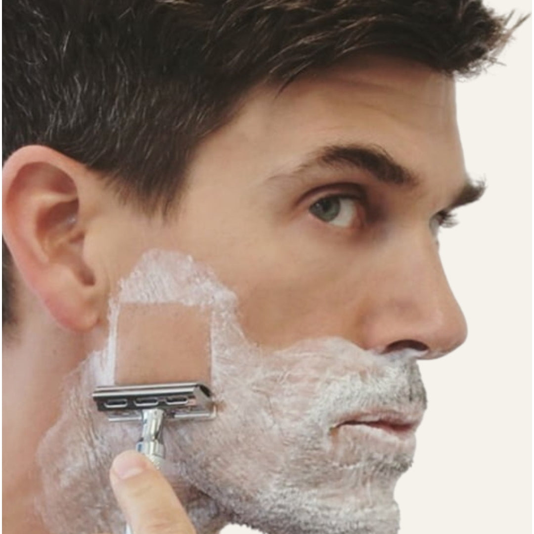 Man shaving his cheek with a 6C double-edge safety razor, lifestyle shot