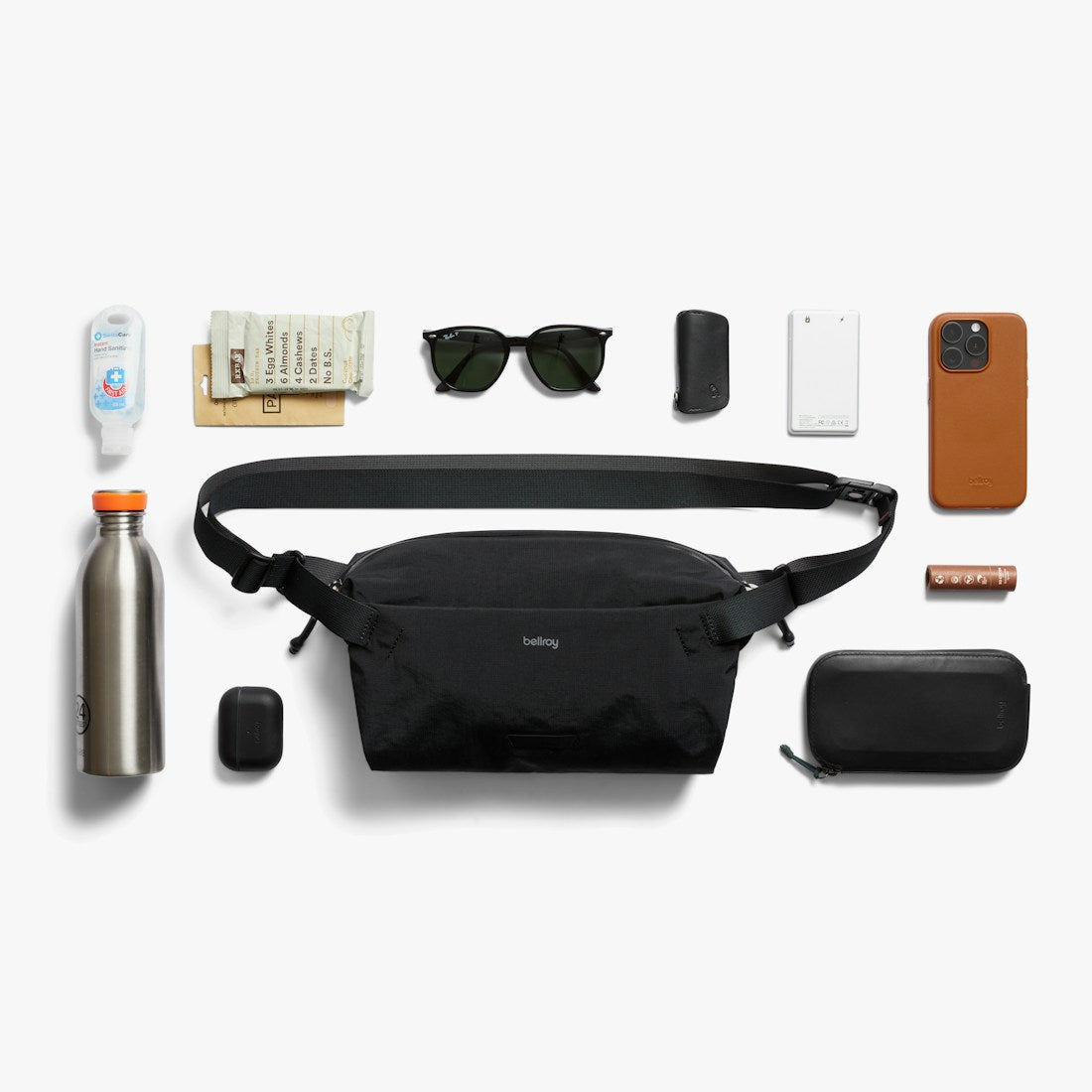 Bellroy Lite Sling in Black, flat lay of everyday items with the sling worn at the waist - The Simple Man