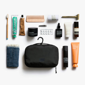 Bellroy Hanging Toiletry Kit in Black, flat lay of toiletries with the kit hanging - The Simple Man