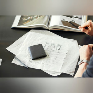 Bellroy Note Sleeve RFID leather wallet in Black, on a desk beside papers - The Simple Man