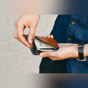 Bellroy Card Pocket wallet, shown in tan leather with hands pulling a card out - The Simple Man