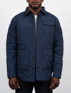 Man wearing the navy down filled quilted shirt jacket over a white tee, front view on model - The Simple Man
